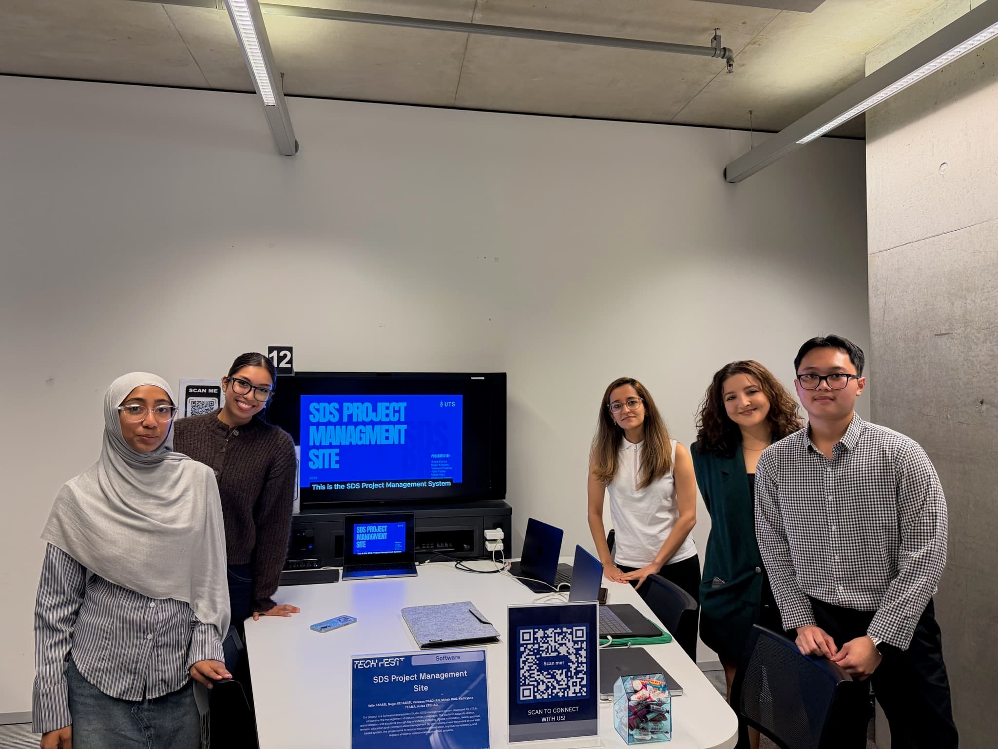Group photo beside the SDS Project Management Site booth and live display
